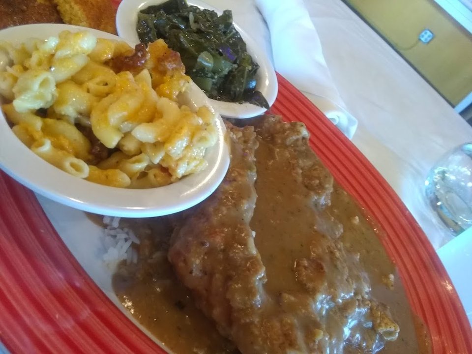 Restaurant menu featuring catfish, oxtails, and mac and cheese.