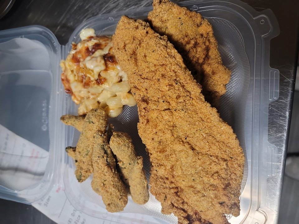 Restaurant menu featuring catfish, oxtails, and mac and cheese.